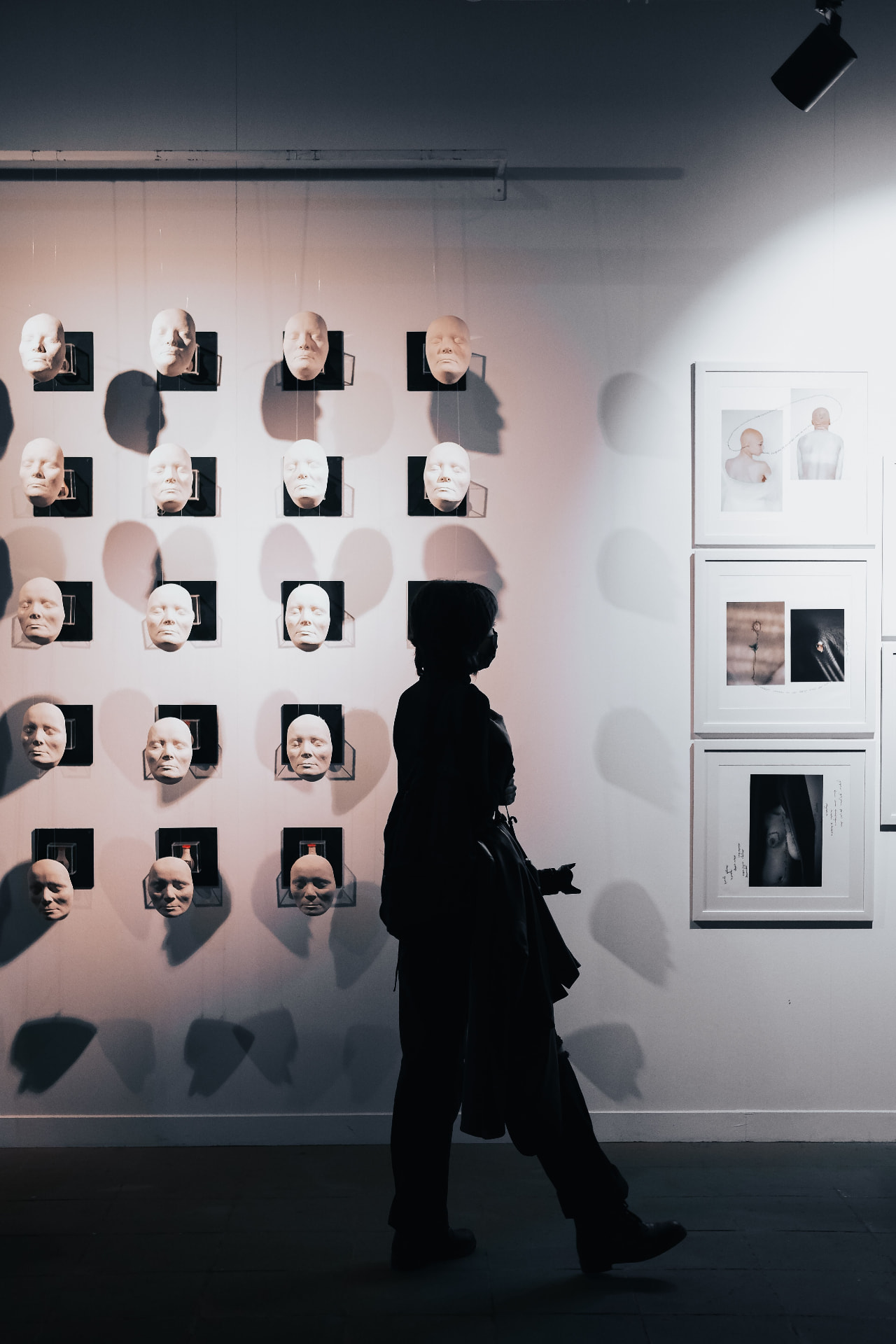 Visitor studying sculptural faces at a Buchanan & Co. exhibition